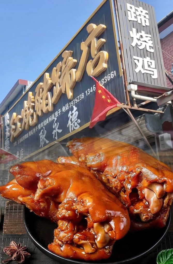 许昌襄城县王洛镇耿永德红烧猪蹄店门口，黑色招牌金字，真空包装礼盒与现卤猪蹄并列展示